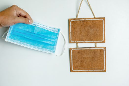 Sanitary mask and wooden sign on a white background