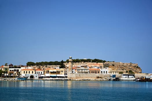 stone wall and historic lighthouse in the port of Rethymnon on the island of Crete