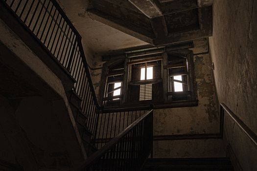 USA, New York, Ellis Island - May 2019: View up wooden stair case in boarded up, dilapidated house