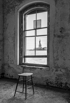 USA, New York, Ellis Island - May 2019: View of the Statue of Liberty through the window of the Contagious Diseases ward at Ellis Island Hospital
