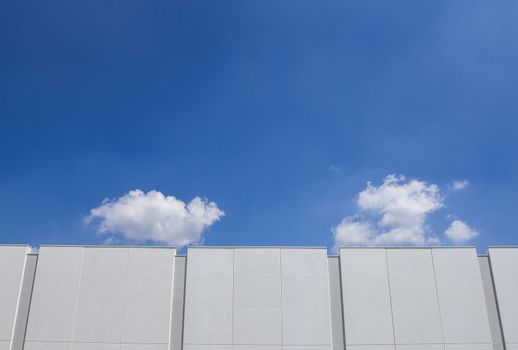 Facade of a newly built factory, with blue sky in the background.