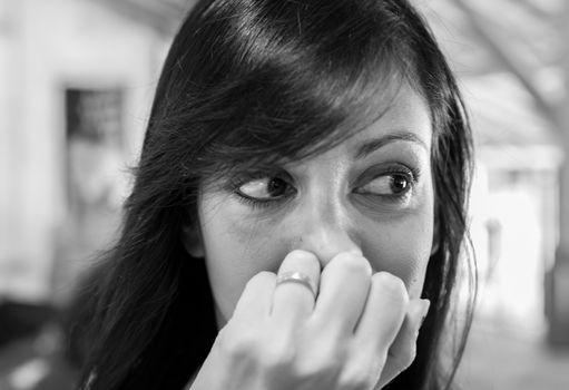 Close up portrait of young woman looking for something. Defocused blurry background.