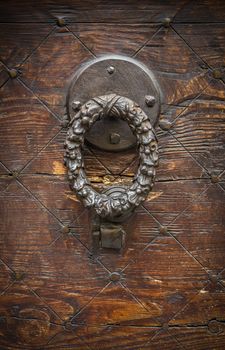 Vintage image of ancient door knocker on a wooden door