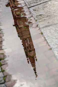 France, Strasbourg - June 2015: A spire of the Notre Dame du Strasbourg reflected in a puddle