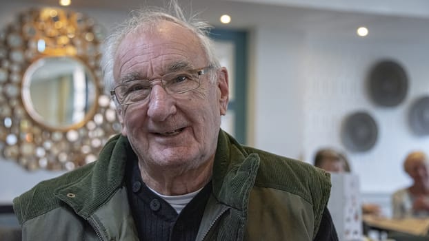 UK, LEICESTERSHIRE - October 2018: Elderly man smiles into camera 