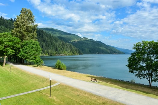 View of Harrison lake and mountains with walk way along the shore in front