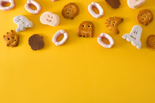 Assortment of Halloween cookies on yellow background