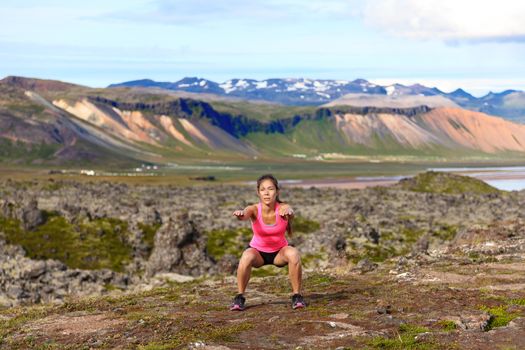 Fitness girl exercising outdoors doing jump squat in amazing nature landscape. Fit female woman athlete cross-training outside. Image from Iceland.