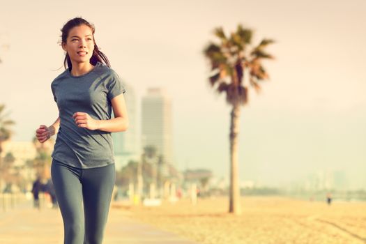 Running woman jogging on beach boardwalk. Healthy lifestyle girl runner training outside working out. Mixed race Asian Caucasian fitness woman exercising outdoors.