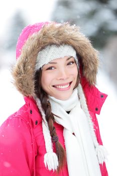 Winter woman in snow outside in nature. Portrait closeup outdoors in snow. Happy beautiful smiling multicultural Asian Caucasian girl.