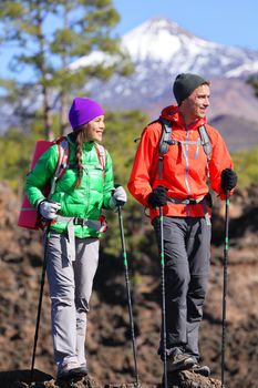Hikers people hiking - healthy active lifestyle. Hiker couple hiking in beautiful mountain nature landscape. Woman and man hikers walking during hike on volcano Teide, Tenerife, Canary Islands, Spain.
