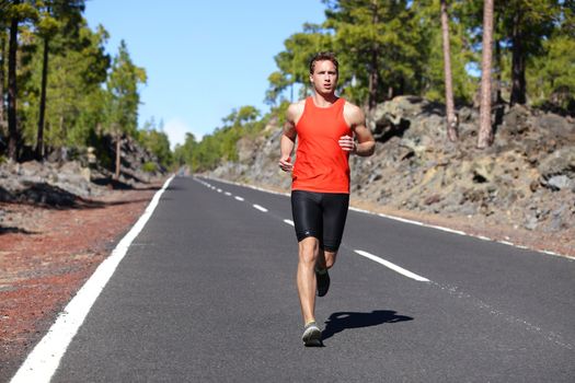 Running man - male runner jogging outdoors on road training for marathon run as part of healthy lifestyle. Close up of fit fitness model during outdoor workout in summer. Caucasian guy.