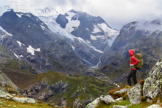 Hiking - hiker woman on trek with backpack living healthy active lifestyle. Hiker girl walking on hike in mountain nature landscape in Steingletscher, Urner Alps, Berne, Swiss alps, Switzerland.