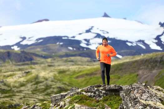 Running man exercising - trail runner athlete. Fit male sport fitness model training and jogging outdoors living healthy lifestyle in beautiful mountain nature, Snaefellsjokull, Snaefellsnes, Iceland.