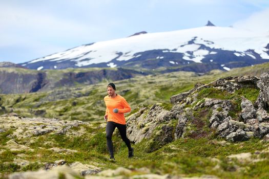 Running man athlete exercising trail runner. Fit male sport fitness model training and jogging outdoors in beautiful mountain nature landscape by Snaefellsjokull, Snaefellsnes, Iceland.