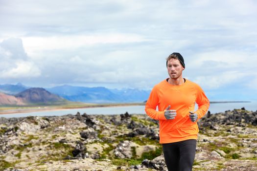 Sport running man in cross country trail run. Male runner exercising and training outdoors in beautiful mountain nature landscape on Snaefellsnes, Iceland.