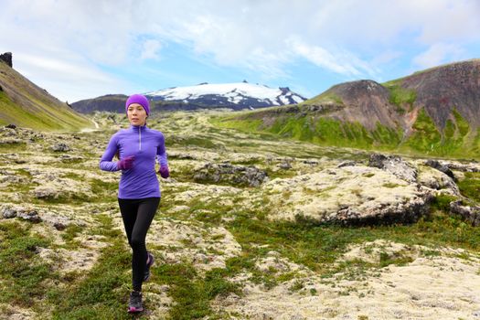 Athlete trail runner - running woman exercising. Fit female sport fitness model training jogging outdoors living healthy lifestyle in beautiful mountain nature, Snaefellsjokull, Snaefellsnes, Iceland.