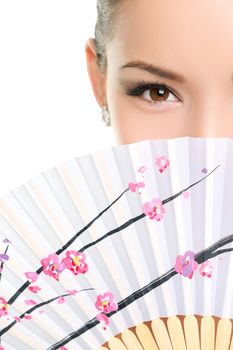 Asian chinese woman looking seductive with paper fan. Beauty portrait of female model face with closeup on eyes.