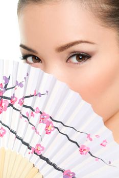 Asian beauty - seductive eyes woman chinese or japanese. Eye makeup Asian look with paper fan. Beauty portrait of mixed race Asian / Caucasian female model on white background. Close up on eyes.