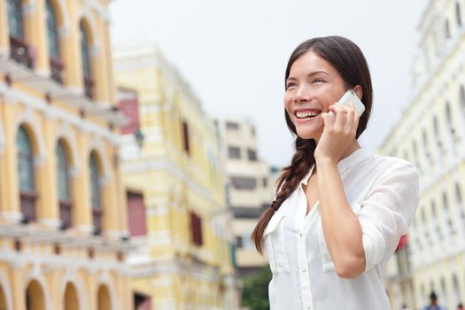 Business woman talking on smart phone in Macau, China. Asian businesswoman using smartphone talking having conversation in Macau on Senado Square or Senate Square.