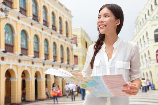 Tourist holding travel map in Macau. Woman visiting Macau, China for sightseeing looking for directions at tourists map smiling happy on Senado Square or Senate Square.