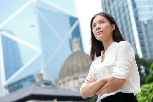 Business woman confident portrait in Hong Kong. Businesswoman standing proud and successful in suit cross-armed. Young multiracial Chinese Asian / Caucasian female professional in central Hong Kong.
