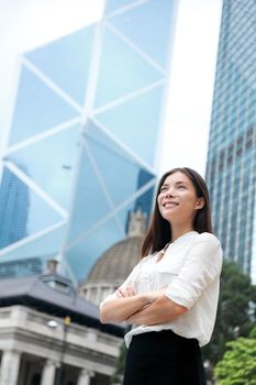 Asian business woman confident outdoor in Hong Kong standing proud in suit cross-armed in business district. Young mixed race female Chinese Asian / Caucasian female professional in central Hong Kong.