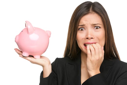 Money stress - business woman holding piggy bank. Debt, bankruptcy and savings concepts with stressed female businesswoman biting nails nervous isolated