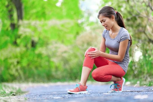 Knee Injury - sports running knee injuries on woman in pain. Female runner with pain from sprain knee. Close up of legs, muscle and knee outdoors.