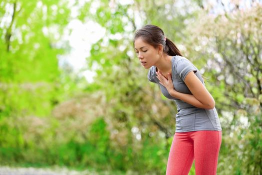 Nausea - nauseous and sick ill runner vomiting. Running woman feeling bad about to throw up. Girl having nausea from dehydration or chest pain.