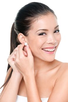 Woman putting on diamond earrings. Asian beauty lady trying and shopping jewelry. Multicultural Asian Caucasian girl on white background.