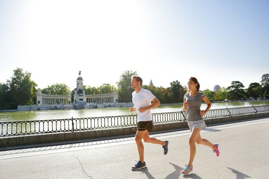 Runners jogging running in Madrid El Retiro city park. Exercising woman and man runner training on jog living healthy lifestyle in Buen Retiro Park, Parque el Retiro in Madrid, Spain, Europe.