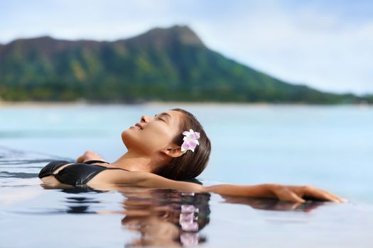 Hawaii vacation wellness pool spa woman relaxing in warm water at luxury hotel resort. Young adult at Waikiki beach in Honolulu, Oahu, Hawaii, USA.