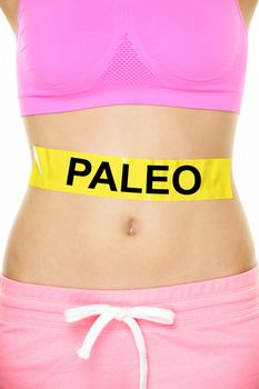 Paleo diet concept - closeup of woman's stomach to show eating concept. New trend in nutrition based on hunter gatherer consumption of proteins. Yellow label as warning or caution applied on body.