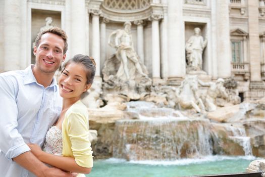Rome travel - tourist couple on travel by Trevi Fountain in Rome, Italy. Happy young romantic couple traveling in Europe taking self-portrait with smartphone camera. Man and woman happy together
