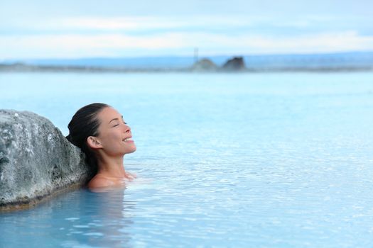 Geothermal spa. Woman relaxing in hot spring pool on Iceland. Girl enjoying bathing in a blue water lagoon Icelandic tourist attraction.