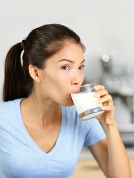 Almond milk woman drinking lactose-free beverage. Young Asian adult sipping a glass of organic soy based or nut milk drink as a dairy substitute for a vegan diet.