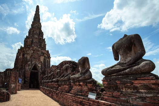 Ayutthaya, Thailand - August 22, 2018: Old pagoda and ruined Buddha statue in Chaiwatthanaram temple. This is the famous travel destination in Ayutthaya province, Thailand.