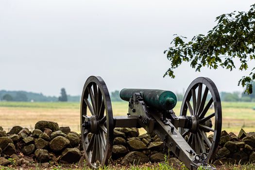 A Civil War era cannon is placed behind a stone wall in Gettysburg, PA