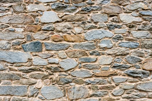 Old, different colors stone wall background texture close up