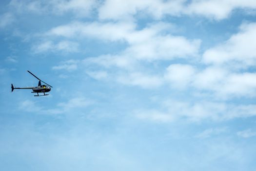 Helicopter silhouette on a light blue sky background