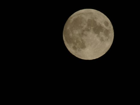 Genova, Italy - 07/05/2020: An amazing photography of the full moon over the city of Genova by night with a great clear and blue sky in the background and some stars.