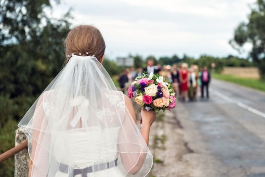 Bride with bridal bouquet in the hands of the groom expect.
