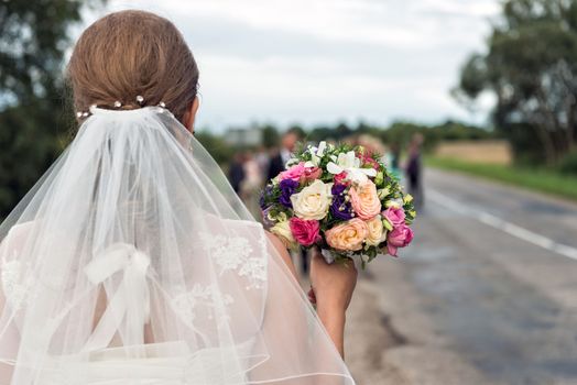 Bride with bridal bouquet in the hands of the groom expect.