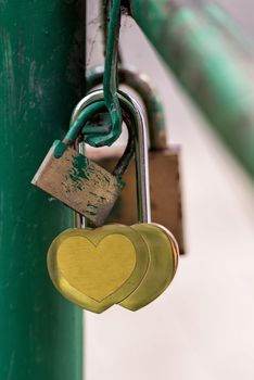 At the iron bridge railing closing a heart-shaped padlocks.