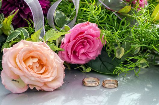 Flower decoration and a ring set on gray wedding car bonnet.