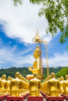 Row of disciple statues surrounding big buddha statue in public to the general public worship worship of Nakhon Nayok, Thailand.