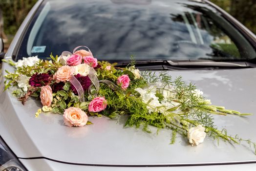 Flower decoration on gray wedding car bonnet.