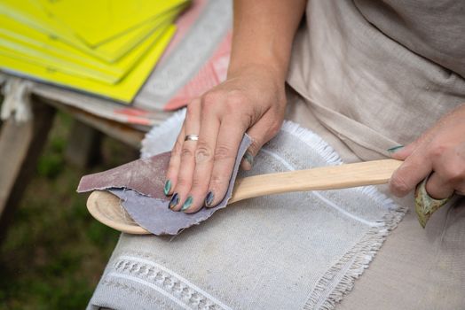 the woman makes traditional handcraft wooden spoon. - Image