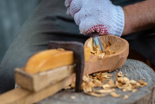 Craftsman demonstrates the process of making wooden spoons handmade using tools. National crafts concept.